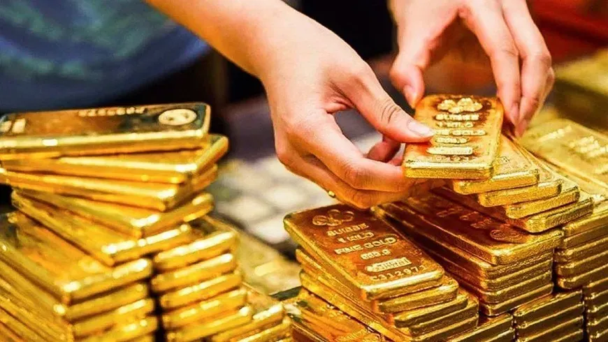 Hands arranging stacks of gold bars